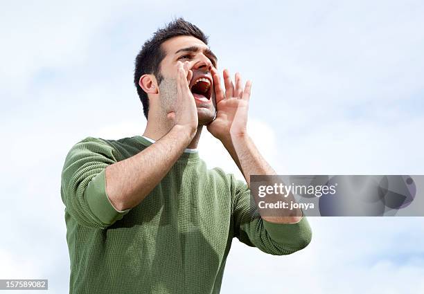 man with hands around mouth to shout in distance - schreeuwen stockfoto's en -beelden