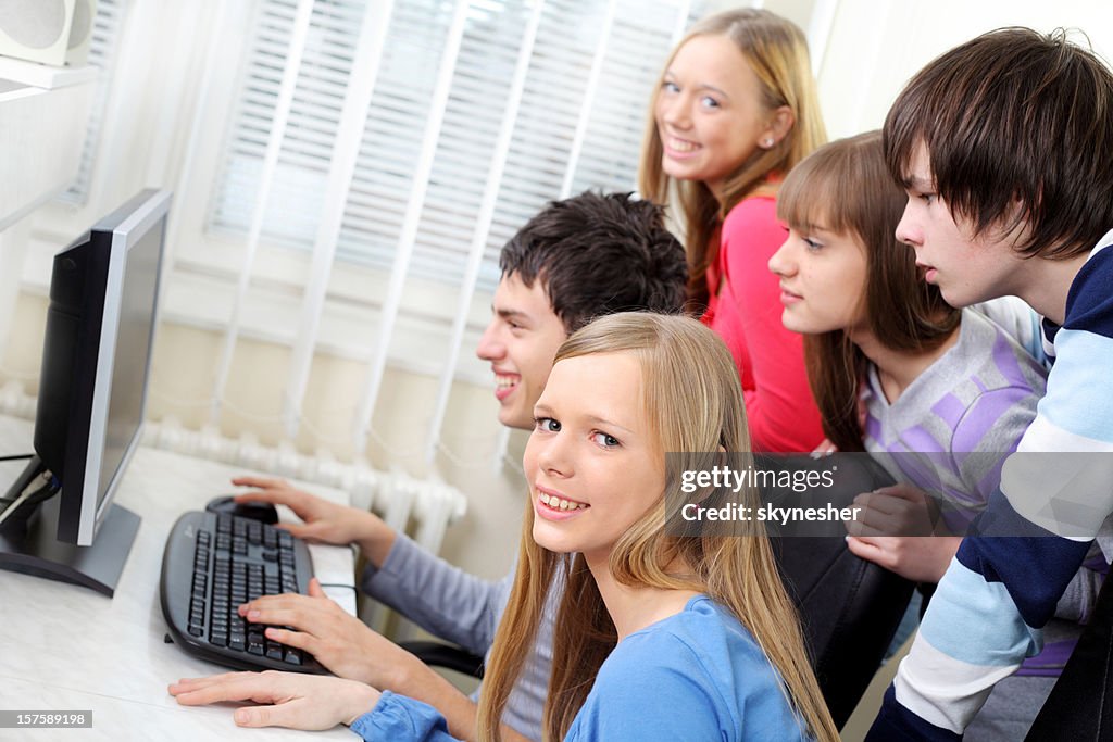 Group Of Young Students Is Using A Computer Together High-Res Stock ...
