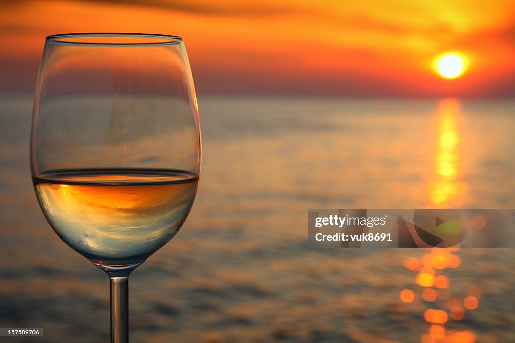 Hermosa puesta de sol rojo y una copa de vino