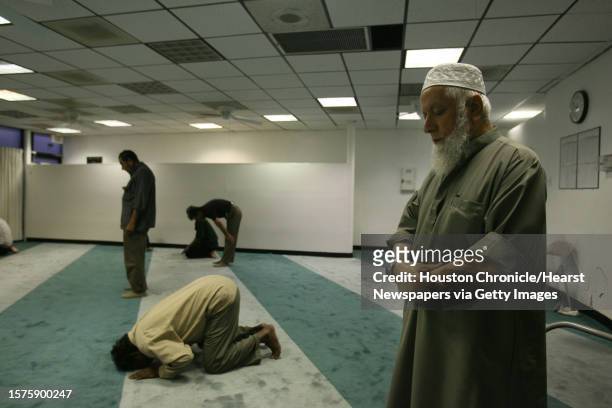 Mohammed Aqil, owner of Jerusalem Art shop, prays at the mosque next to the computer store where 36 undocumented people were found in the attic in...