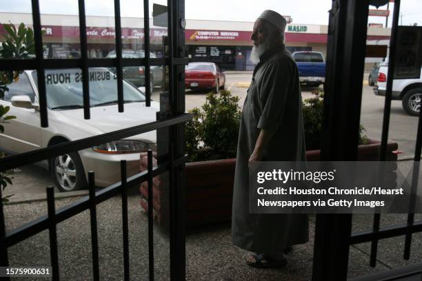 Mohammed Aqil, owner of Jerusalem Art shop, stands across from the computer store where 36 undocumented people were found in the attic in 2004....