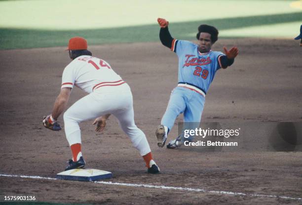 The Minnesota Twins' Rod Carew slides into his second triple of the day as the Cincinnati Reds' Pete Rose waits for the throw, San Diego, California,...