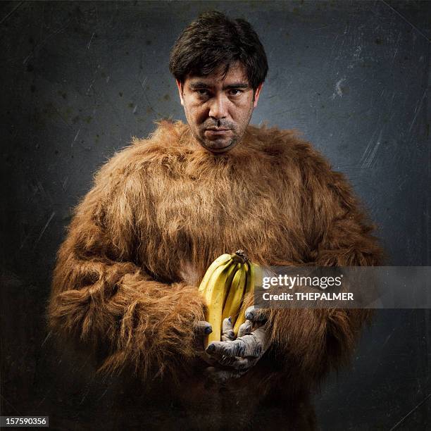 guy with gorilla custome and bananas - hairy man stockfoto's en -beelden