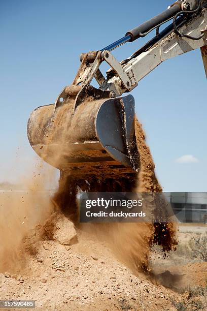 backhoe dumping rundem von schmutz - digger stock-fotos und bilder