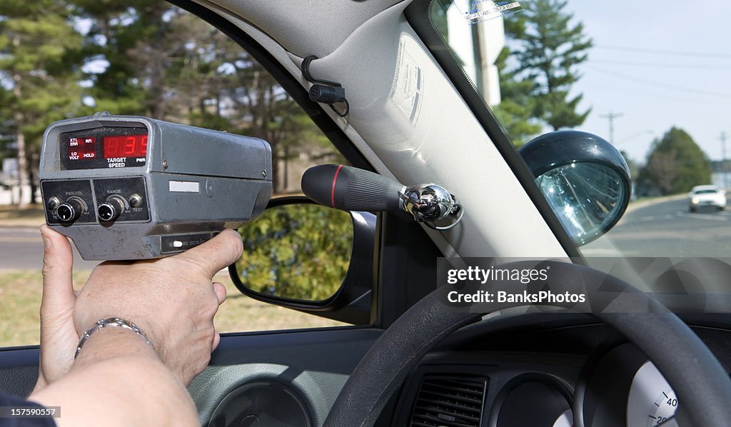 Oficial de policía utilizando una pistola RADAR portátil