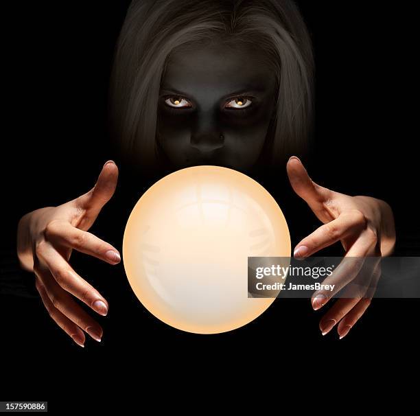 mysterious fortune teller gazes into crystal ball seeing the future - magic ball stockfoto's en -beelden