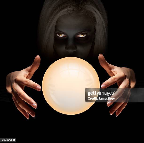 mysterious fortune teller gazes into crystal ball seeing the future - glass ball stock pictures, royalty-free photos & images