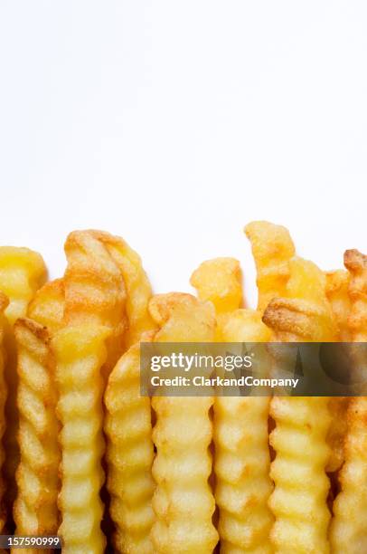 crinkle cut oven chips or french fries white background - crinkle cut fries stock pictures, royalty-free photos & images