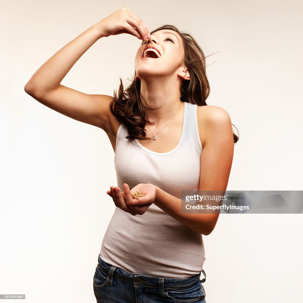 Healthy eating. Young woman eating nuts. Square format.