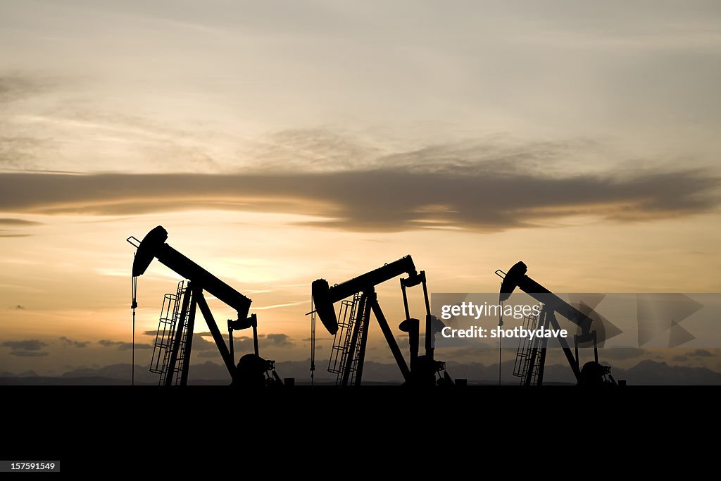 Três Pumpjacks amarelas e um céu