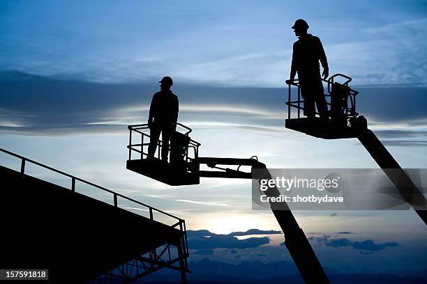 two construction lifts - cherry picker crane stock pictures, royalty-free photos & images