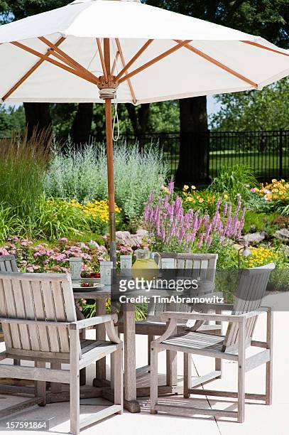 a garden patio with big white umbrella - patio furniture stock pictures, royalty-free photos & images