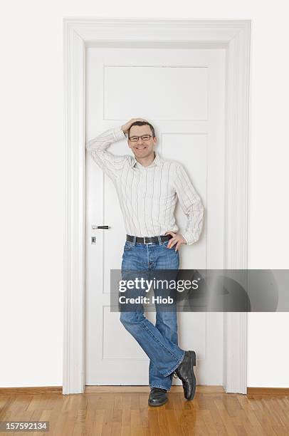 smiling man standing in a doorway - black jeans stock pictures, royalty-free photos & images