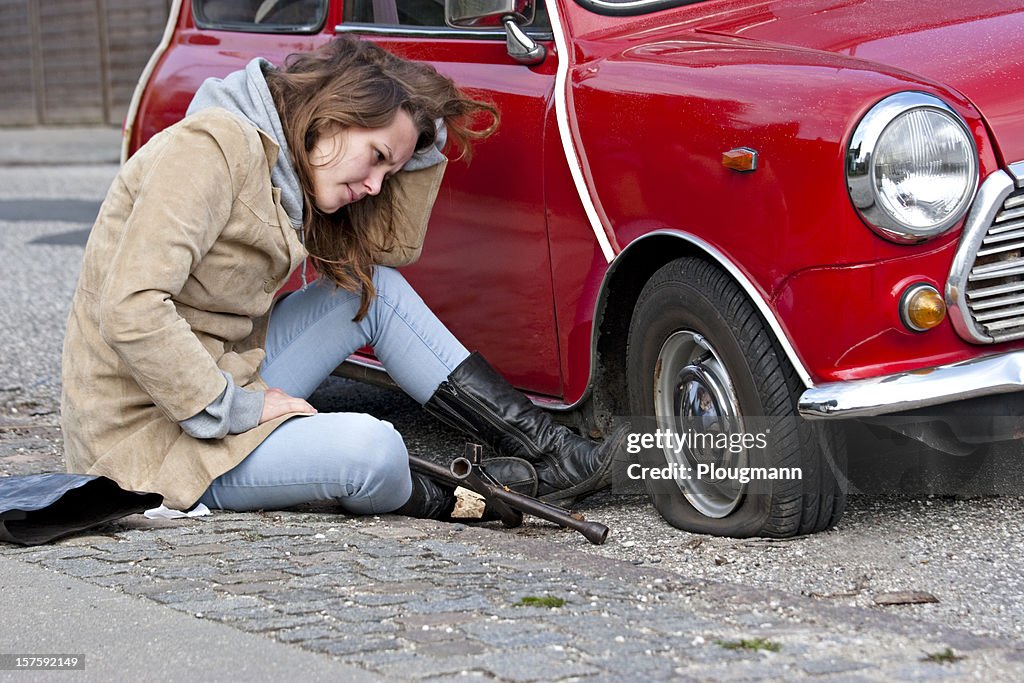 Young woman with a flat tire