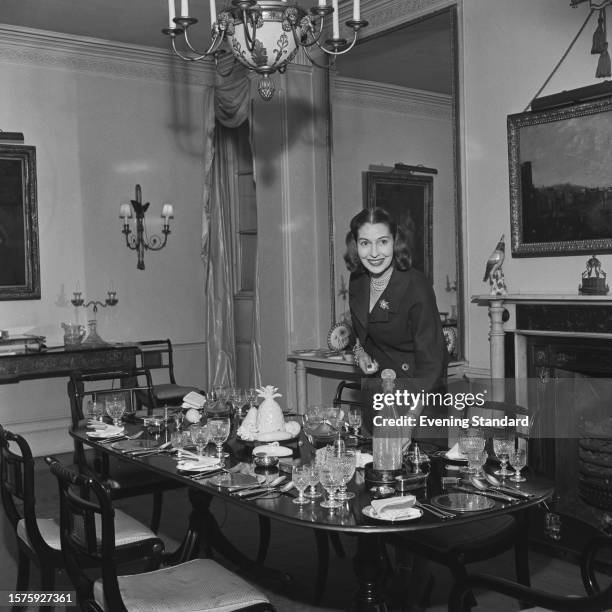 British actress Valerie Hobson , wife of Foreign Minister John Profumo, standing next to a table laid for dinner, November 20 1959.