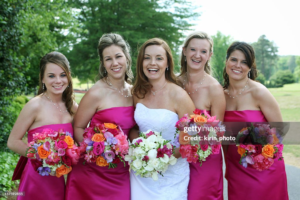 Joyous pink clad bridesmaids surround the bride