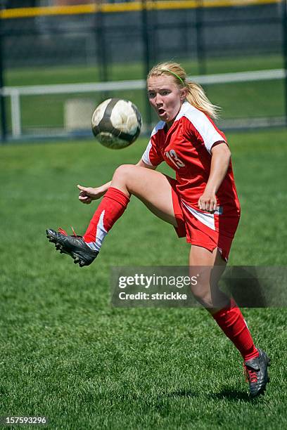 female soccer player trapping airborn ball - soccer dribbling stock pictures, royalty-free photos & images