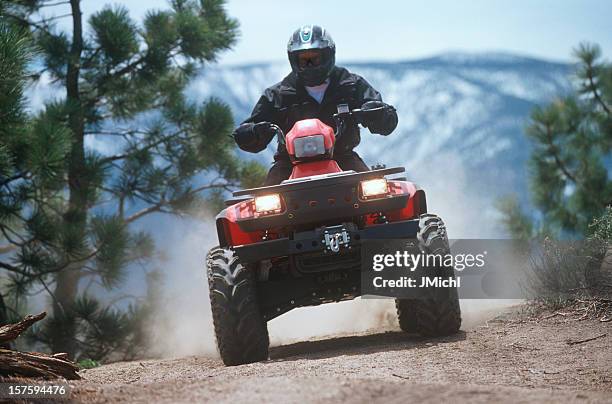 atv traveling down a dust mountain trail. - off road vehicle stock pictures, royalty-free photos & images