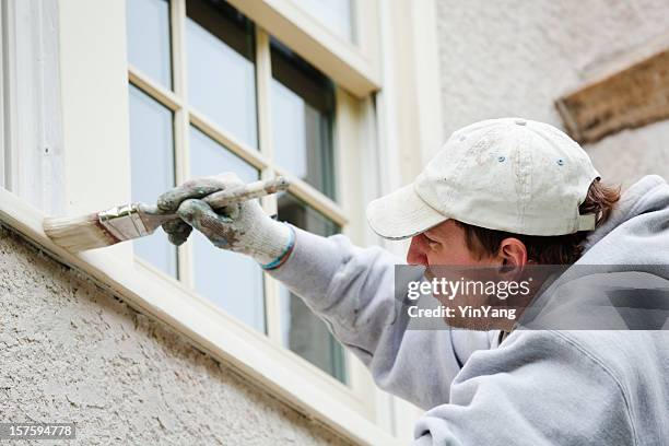 house painter repairman painting window for home improvement and repair - windowframe stockfoto's en -beelden