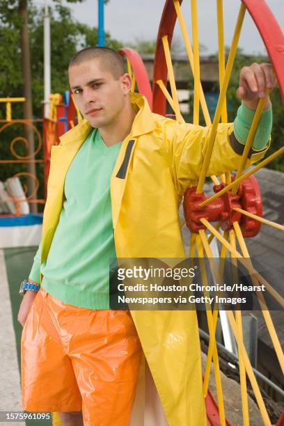 Scott Kondziela of Page Parkes Models wears Prada orange vinyl shorts, yellow vinyl rain slicker and grey vinyl shoes, Lacoste green cotton V-neck...