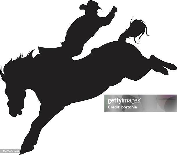 cowboy riding a bucking bronco silhouette - bucking stock illustrations
