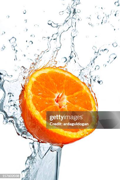 a orange being washed on white backdrop - citrus splash stock pictures, royalty-free photos & images