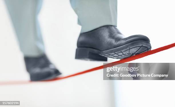 business mann zu fuß auf dünne linie zeigt zweifel job - tightrope walking stock-fotos und bilder