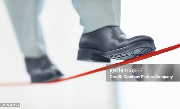 business man walking on thin line depicting uncertainty job - tightrope walker stock pictures, royalty-free photos & images