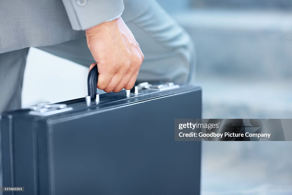 Close-up of a young businessman carrying briefcase