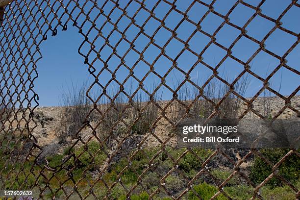 fence with hole - illegale immigrant stockfoto's en -beelden