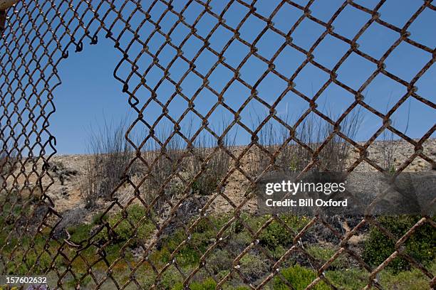 fence with hole - illegal immigrant stock pictures, royalty-free photos & images