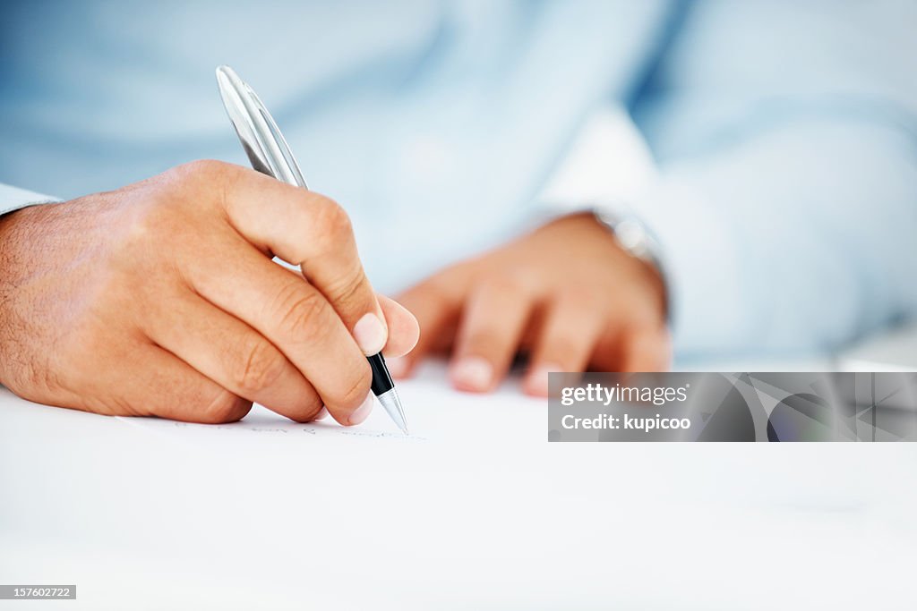 Close-up of a business man writing on paper