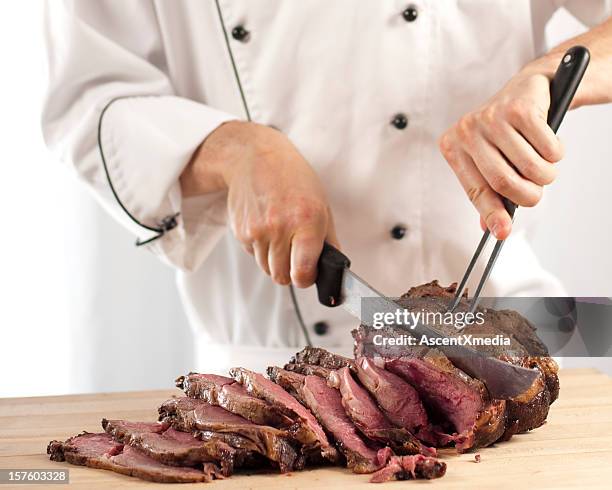 chef slicing roast beef using carving knife and fork - skära mat bildbanksfoton och bilder