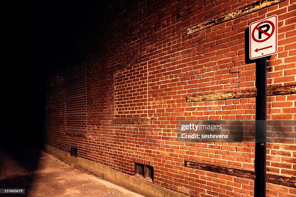 No parking sign leading to dark alley