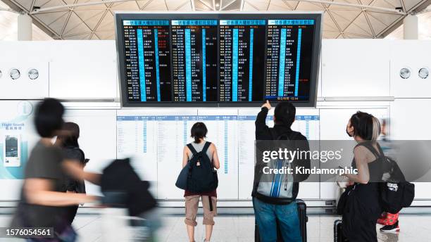motion blur asian tourist traveler people walk at hong kong international airport terminal, arrival departure information board. oversea transportation, airline transport business, asia travel concept - priority boarding stock pictures, royalty-free photos & images