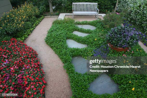 David Morello's Heights home lies between lush gardens with granite and stone pathways that shape the garden with varying 'hardscapes' on April 23,...