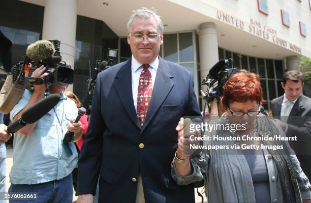 District Judge Samuel Kent holds his wife's hand as she walks away from the Bob Casey Federal Court House after being sentenced 33 months behind bars...