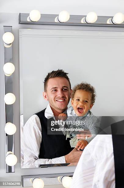 young adult and baby looking in the mirror smiling - theatre dressing room stock pictures, royalty-free photos & images