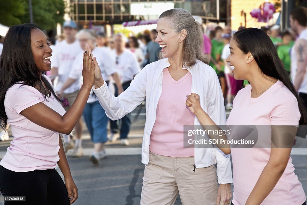 Women Cheering Each Other On at Cancer Awareness Event