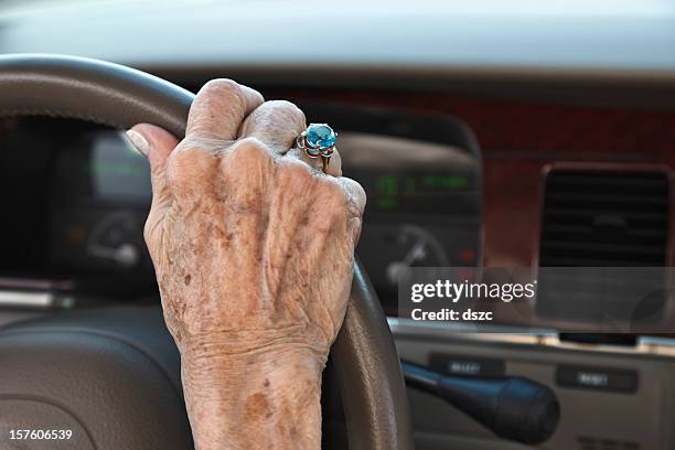 senior mujer de la mano en el volante - liver spot fotografías e imágenes de stock