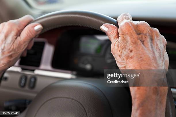 senior frau hand auf dem lenkrad - eine seniorin allein stock-fotos und bilder