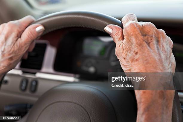 senior donna con le mani sul volante - steering wheel foto e immagini stock
