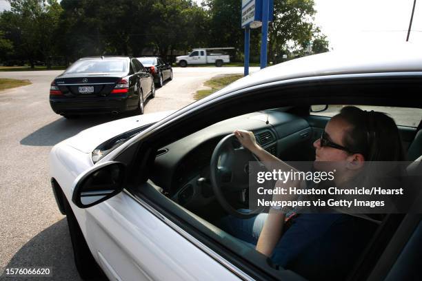 Receptionist Samantha Burke drives out of the business center where she works at Manor Lane Properties during rush hour along F.M. 359, a two lane...