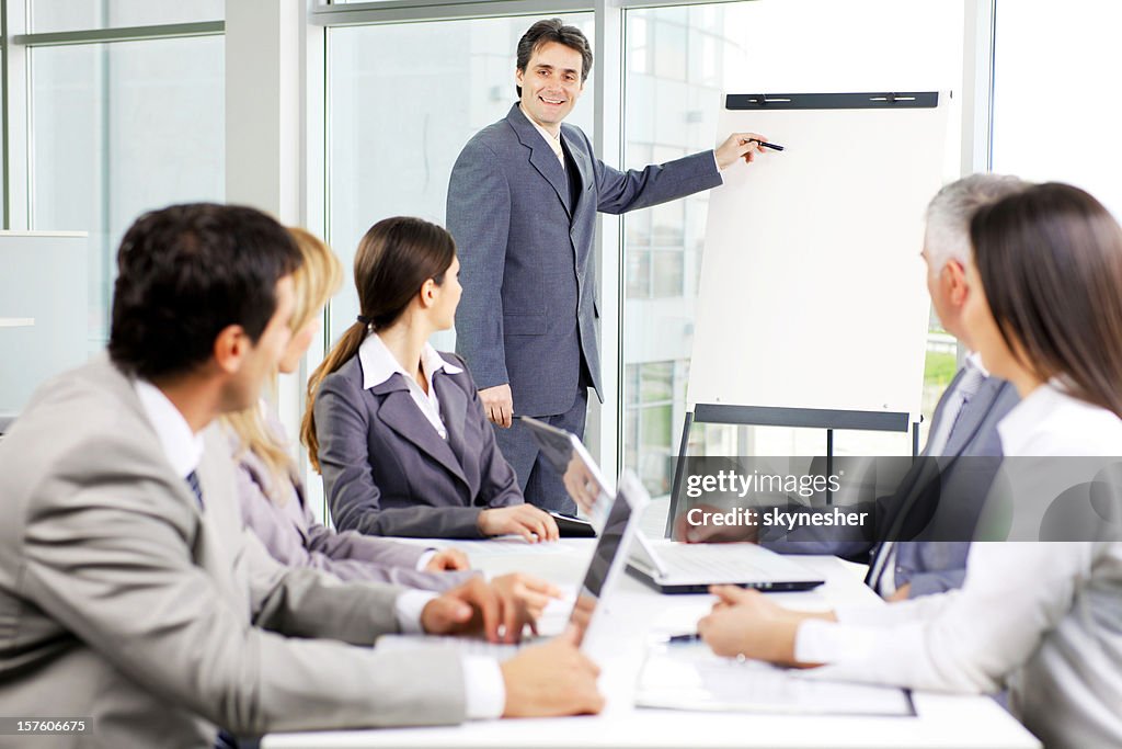Business man pointing to flipchart.