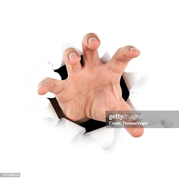 gripping hand . reaching paper catching tearing hole - catching hands stock pictures, royalty-free photos & images