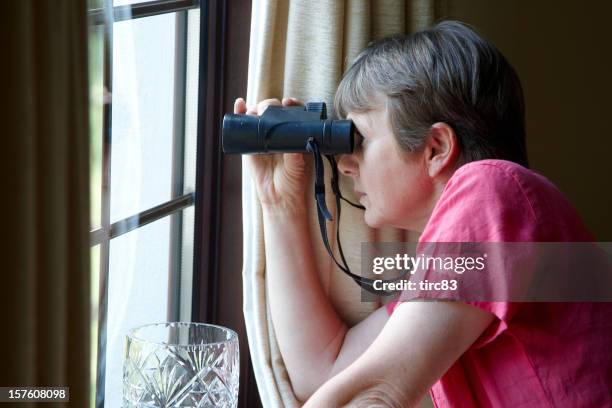 neugierig nachbarn am fenster mit fernglas - nosey neighbor stock-fotos und bilder