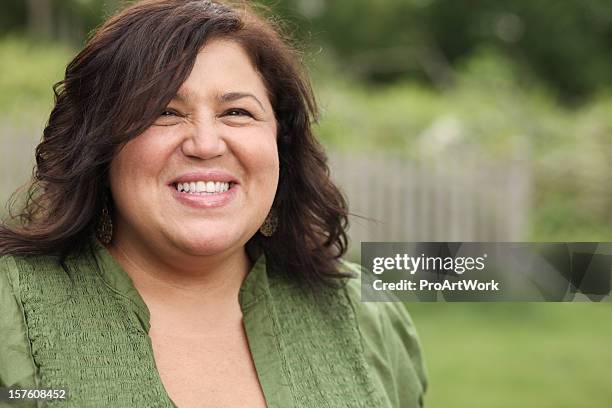 cheerful woman smiling for a photograph - fat women art stock pictures, royalty-free photos & images