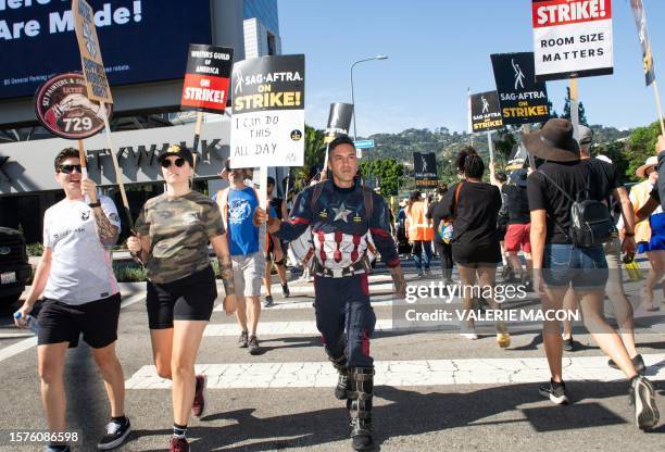 Argentine actor Eduardo Lezcano, dressed as Captain America, joins members of the Writers Guild of America and the Screen Actors Guild as they walk...