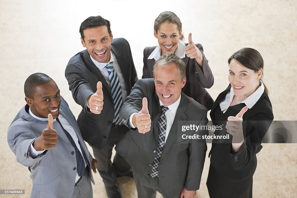 Arial view of mature mixedrace business team holding thumbs up