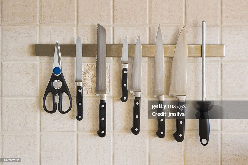 Kitchen knives magnetized on the backsplash